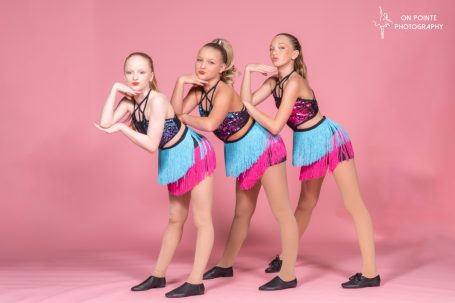 trio of dancers on pink background